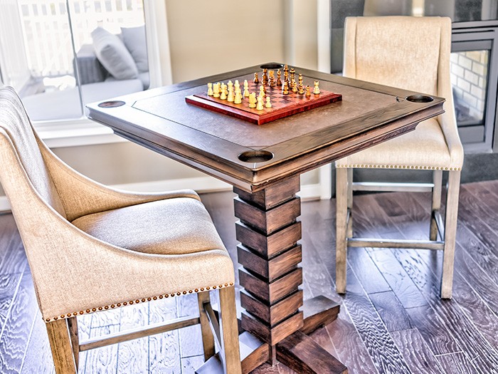 A card table with a chessboard and two chairs.
